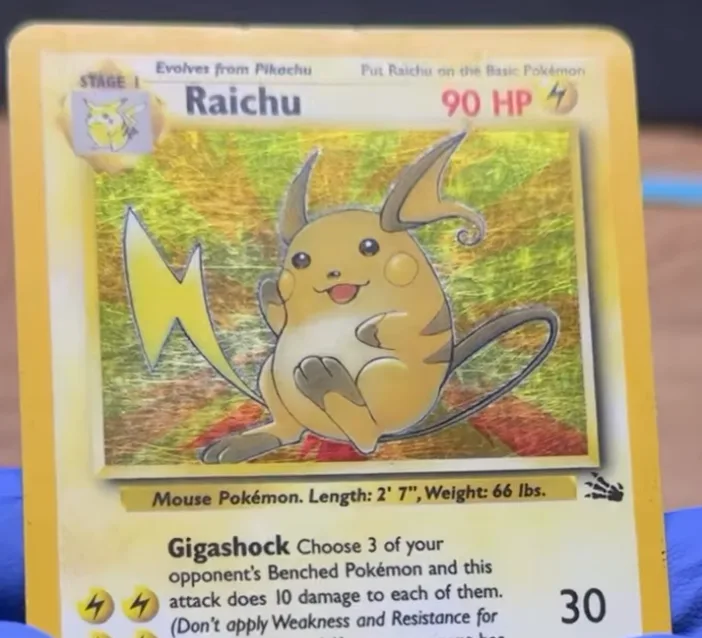 Surface scratches catching the light on a holo card